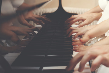 Family of three members playing a piano together