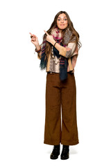 Full-length shot of Young hippie woman frightened and pointing to the side on isolated white background