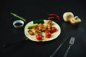Fajita chicken kebabs, with chicken meat, pepper, chili, tomatoes, onions, lime juice and herbs. In a frying pan, on a white wooden table. Mexican cuisine, a traditional food, Close view, copy space