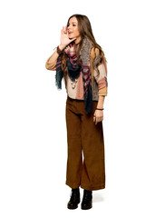 Full-length shot of Young hippie woman shouting with mouth wide open to the lateral on isolated white background