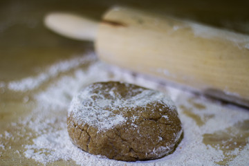 Balls of integral dough with rolling pin on wooden board