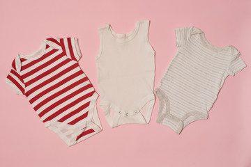 Three baby bodysuit on a pink background. Clothes concept