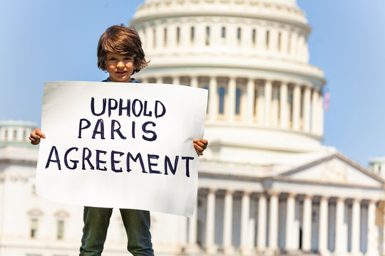 Protester Holding Sign Uphold Paris Agreement In Hands