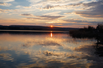 Landscape of pure spring sunset over lake.