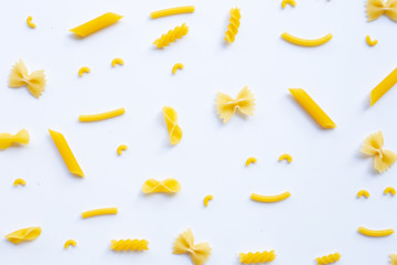 Different types of dry pasta on white.