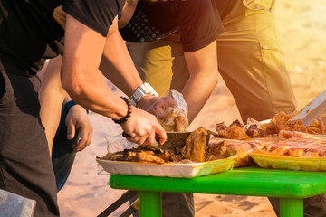 Close up of a group of men doing barbecue outdoor