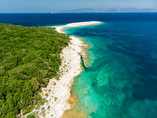 Fototapeta na wymiar Aerial view of Emplisi Beach, picturesque stony beach in a secluded bay, with clear waters popular for snorkelling. Small pebble beach near Fiscardo town of Kefalonia, Greece.