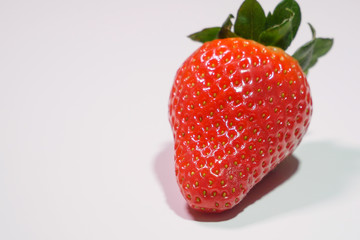 One delicious strawberry on white background. Closeup, space to left for text