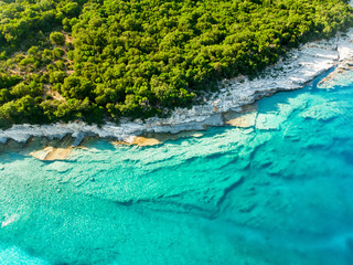 Aerial view of Emplisi Beach, picturesque stony beach in a secluded bay, with clear waters popular for snorkelling. Small pebble beach near Fiscardo town of Kefalonia, Greece.