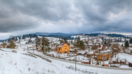 Rural winter landscape - view of the village Vorokhta with the railway in valley Prut River the Carpathian Mountains, in Ukraine