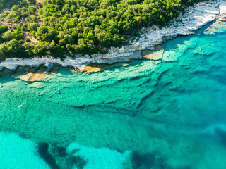 Aerial view of Emplisi Beach, picturesque stony beach in a secluded bay, with clear waters popular for snorkelling. Small pebble beach near Fiscardo town of Kefalonia, Greece.