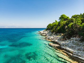Aerial view of Emplisi Beach, picturesque stony beach in a secluded bay, with clear waters popular for snorkelling. Small pebble beach near Fiscardo town of Kefalonia, Greece.