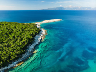 Aerial view of Emplisi Beach, picturesque stony beach in a secluded bay, with clear waters popular for snorkelling. Small pebble beach near Fiscardo town of Kefalonia, Greece.
