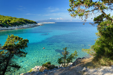 Scenic view of Emplisi Beach, picturesque stony beach in a secluded bay, with clear waters popular for snorkelling. Small pebble beach near Fiscardo town of Kefalonia, Greece.