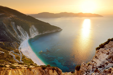 Aerial view of Myrtos beach, the most famous and beautiful beach of Kefalonia, a large coast with turqoise water and white coarse sand, surrounded by steep cliffs.