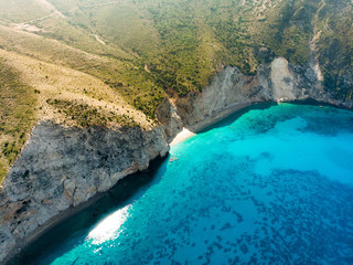 Scenic aerial view of picturesque jagged coastline of Kefalonia with clear turquoise waters, surrounded by steep cliffs.