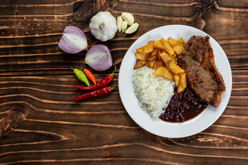 meal on white plate, rice, beans, steak and chips, Wooden Background