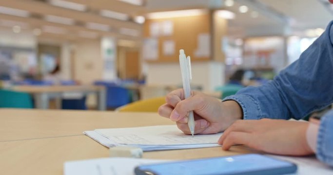 Woman write on the paper at library