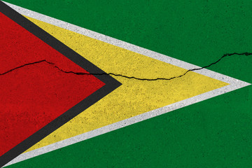 Guyana flag on concrete wall with crack
