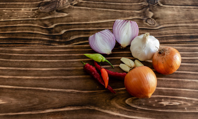 onion, garlic and peppers on wood