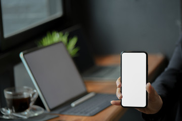 Businesswomen hand showing mobile phone blank screen in the office.