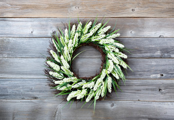 Natural flower wreath on weathered wooden background