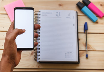 Smartphone en la mano con fondo de espacio de trabajo
