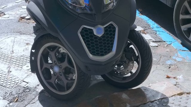 A tricycle is a motorcycle with two front wheels and one rear wheel, parked on the street in the city of Spain. Shot in motion