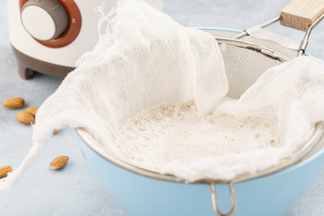 Homemade nut milk making process. Pouring milk into cloth.