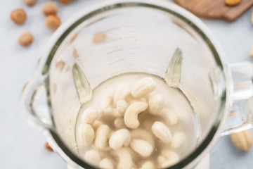 Blender with soaked cashews for making nut milk.