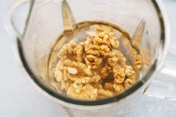 Blender and walnuts soaked in water. Making vegan milk.