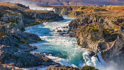 Fototapeta na wymiar What a beautiful day at Godafoss waterfall. The water from cascade powerful streaming to the ocean. Godafoss, Iceland