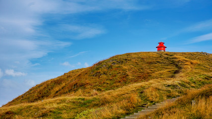 Little red lighthouse on the hill at  Sykkisholmur, Iceland