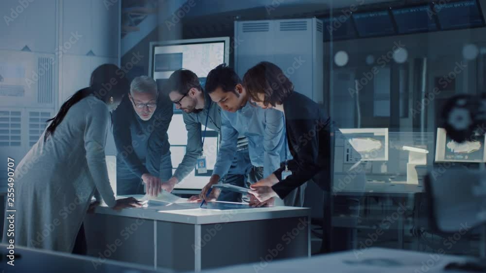 Fototapete Engineers Meeting in Technology Research Laboratory: Engineers, Scientists and Developers Gathered Around Illuminated Conference Table, Talking and Finding Solution. Industrial Design Facility 