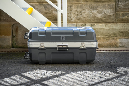 Image of a hard case suitcase on the concrete path