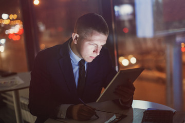 Office manager sits at a table at night.