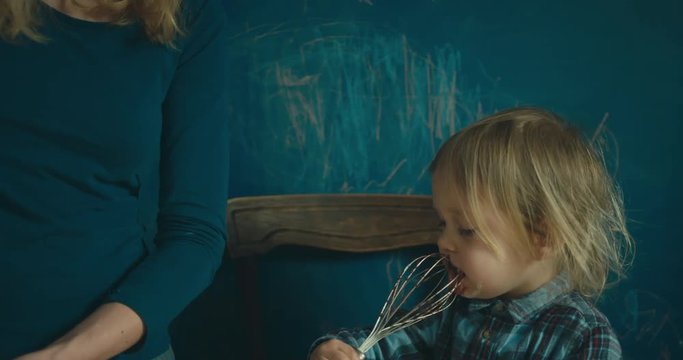 Mother and toddler mixing flour and chocolate for a cake