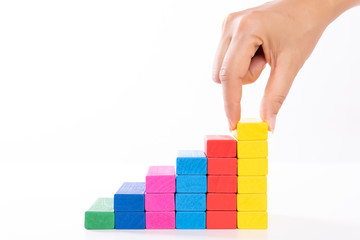 Concept of building success foundation. Women hand put wooden blocks in the shape of a staircase.