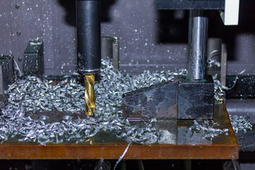 close up tool of automatic drilling machine make hole at metal with cooling by coolant water