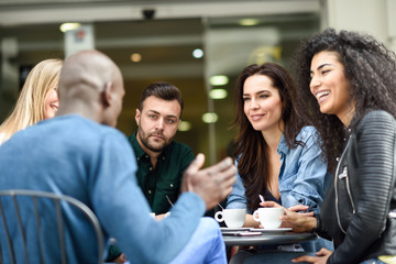 Fototapeta na wymiar Multiracial group of five friends having a coffee together