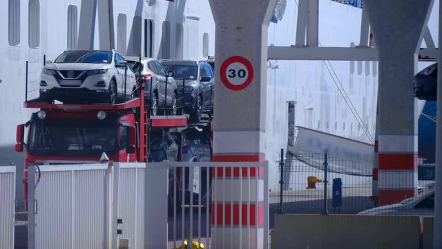 The car transporter leaves the territory of the cargo sea port of Valencia fully loaded with new cars imported from Japan