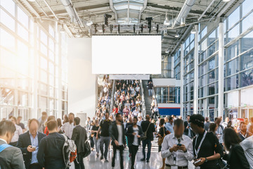 blurred business people at a trade fair, including Copy space