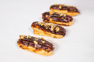 Food, bakery and desserts concept - row of eclairs on white background