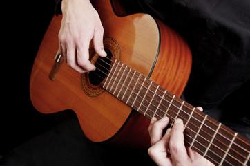 Guitarist plays the guitar. Close-up.