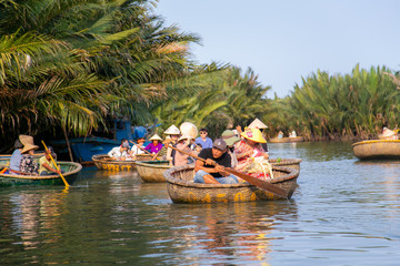 Touring the coconut palm forest on the river in bamboo basket boats - 255497793