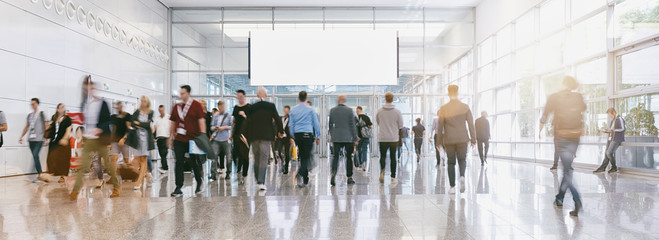blurred business people at a trade fair, banner size