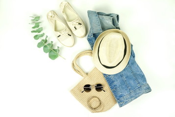 Top view, flat lay fashion women summer clothes and accessories.Straw hat, sunglasses, denim, bag, shoes on white background.
