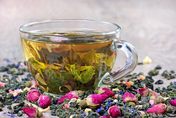 green tea. cup of green tea with flowers and fruit pieces. blend tea