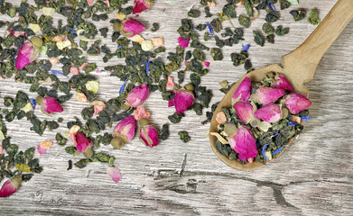 green tea. green tea with flowers in a wooden spoon. green tea with flowers and fruit pieces. blend tea