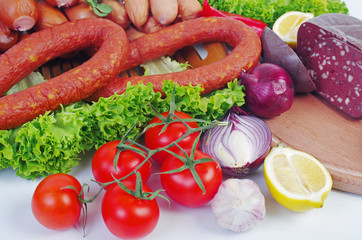 Meat products, sausage, ham, decorated with vegetables and spices on the table